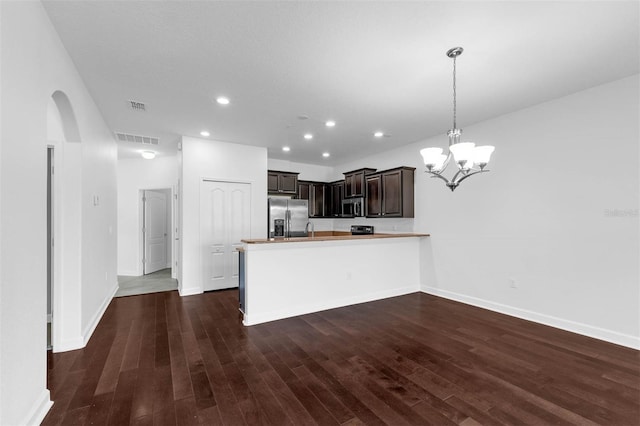 8970 Azalea Sands Ln Unit 2302, Davenport, FL 33896 - kitchen featuring appliances with stainless steel finishes, arched walkways, a peninsula, dark wood finished floors, and dark brown cabinets