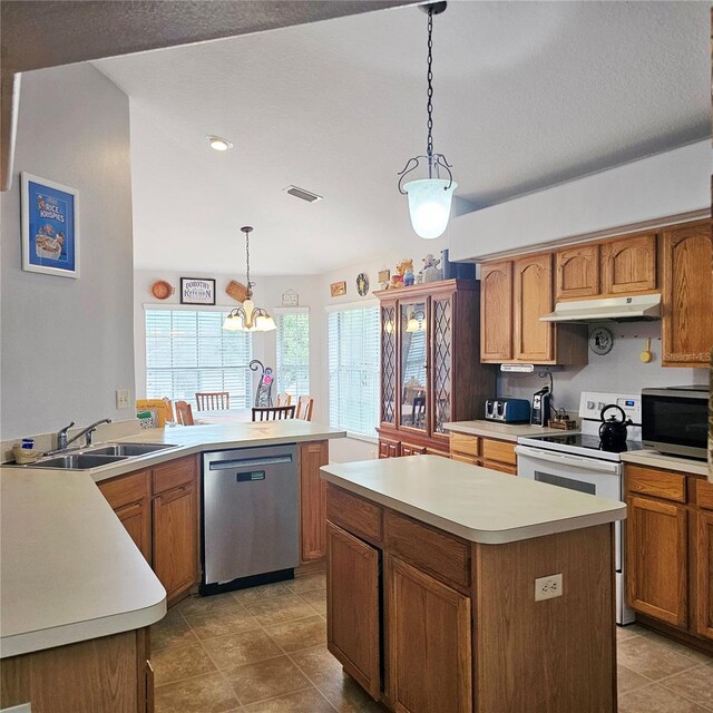 4471 Treasure Cay Rd, Tavares, FL 32778 - kitchen featuring appliances with stainless steel finishes, light countertops, under cabinet range hood, pendant lighting, and a center island
