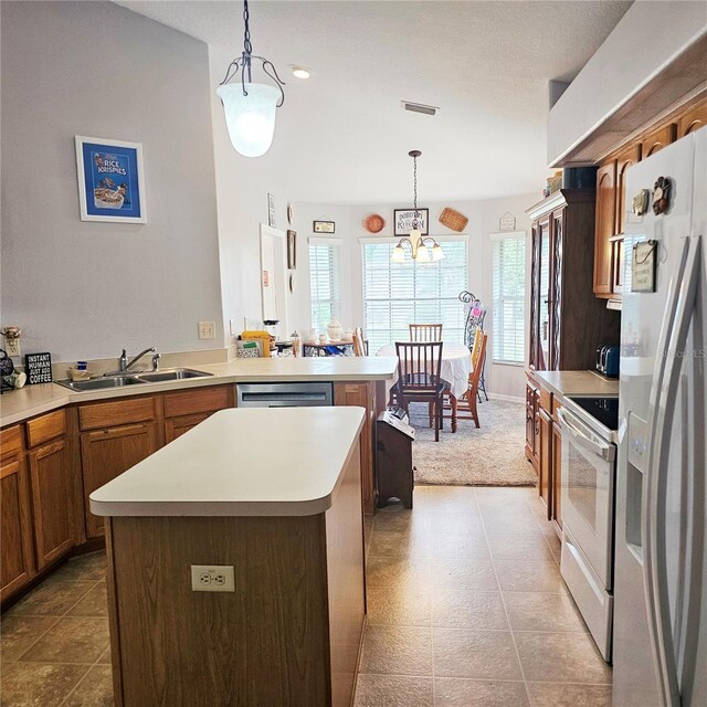 4471 Treasure Cay Rd, Tavares, FL 32778 - kitchen featuring stainless steel appliances, light countertops, brown cabinets, and a peninsula