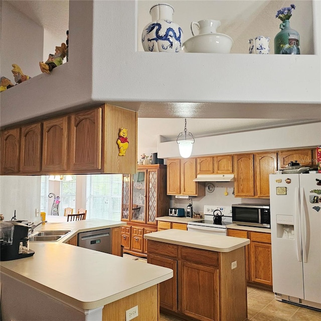 4471 Treasure Cay Rd, Tavares, FL 32778 - kitchen with stainless steel appliances, light countertops, under cabinet range hood, a peninsula, and brown cabinetry