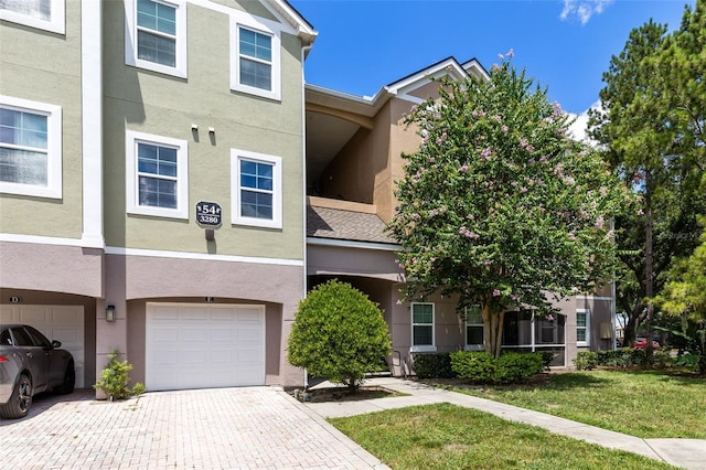 3280 Soho St Unit 306, Orlando, FL 32835 - multi unit property with stucco siding, an attached garage, and decorative driveway