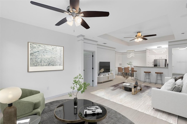 3280 Soho St Unit 306, Orlando, FL 32835 - living area featuring ceiling fan, a tray ceiling, and wood finished floors
