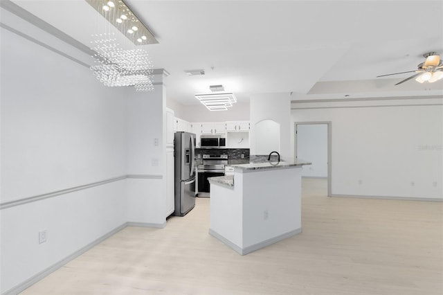 3280 Soho St Unit 306, Orlando, FL 32835 - kitchen featuring appliances with stainless steel finishes, light wood-style floors, a peninsula, a chandelier, and light stone counters