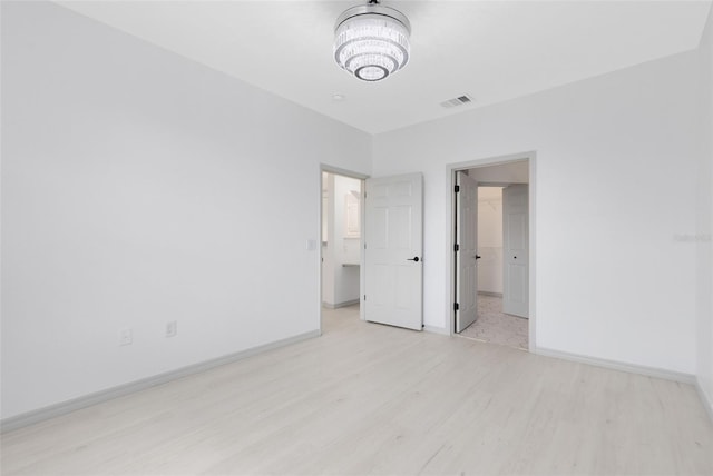 3280 Soho St Unit 306, Orlando, FL 32835 - unfurnished bedroom featuring light wood-style floors, a chandelier, and a spacious closet