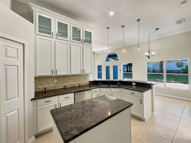 13108 Long Pine Trl, Clermont, FL 34711 - kitchen with stainless steel dishwasher, a peninsula, tasteful backsplash, light tile patterned floors, and white cabinetry