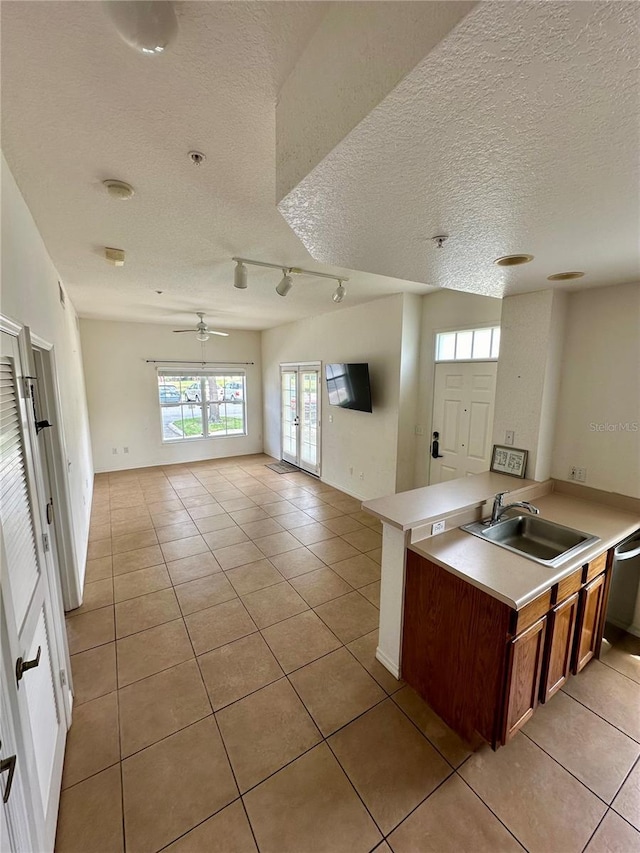 2200 San Vittorino Cir Unit 102, Kissimmee, FL 34741 - kitchen with open floor plan, a textured ceiling, light tile patterned floors, light countertops, and a ceiling fan