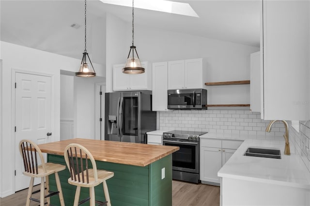 762 Lake Como Dr, Lake Mary, FL 32746 - kitchen featuring appliances with stainless steel finishes, a skylight, wooden counters, lofted ceiling, and a kitchen island