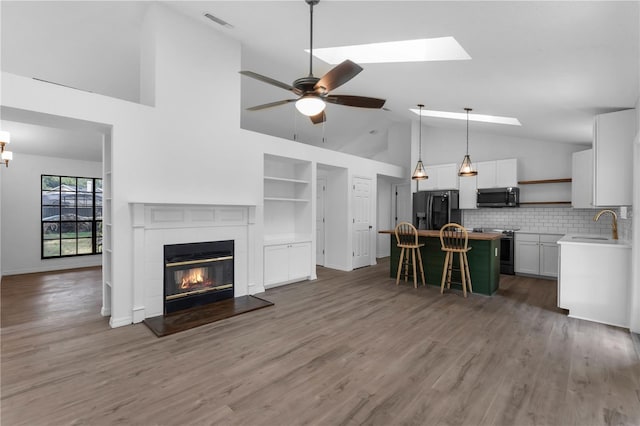 762 Lake Como Dr, Lake Mary, FL 32746 - living room featuring a ceiling fan, high vaulted ceiling, a glass covered fireplace, and wood finished floors