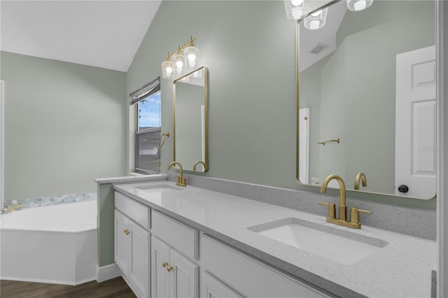 762 Lake Como Dr, Lake Mary, FL 32746 - bathroom featuring lofted ceiling, double vanity, a bath, and wood finished floors