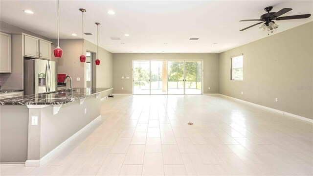 922 Suffolk Pl, Davenport, FL 33896 - kitchen featuring stainless steel fridge with ice dispenser, open floor plan, healthy amount of natural light, dark stone countertops, and recessed lighting