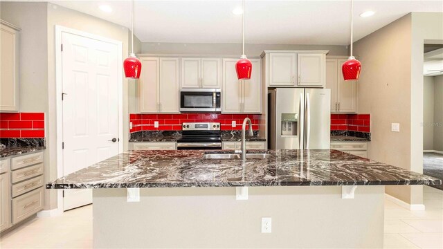 922 Suffolk Pl, Davenport, FL 33896 - kitchen featuring stainless steel appliances, tasteful backsplash, a breakfast bar, recessed lighting, and a center island with sink