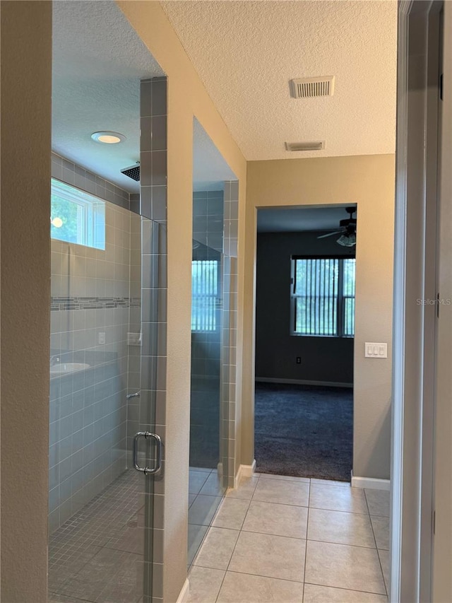 922 Suffolk Pl, Davenport, FL 33896 - bathroom with a textured ceiling, tile patterned flooring, a stall shower, and ceiling fan