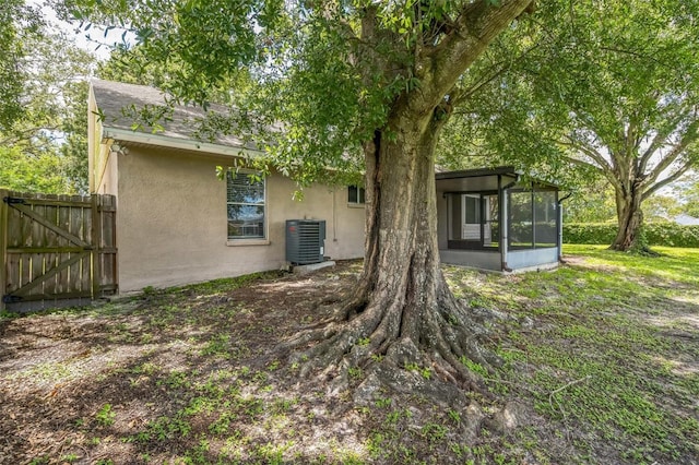 2002 Culpepper Dr, Brandon, FL 33511 - rear view of house with stucco siding, a sunroom, and a gate