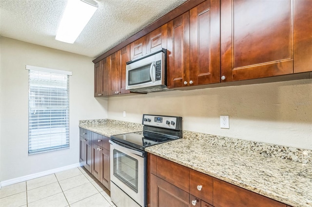 2002 Culpepper Dr, Brandon, FL 33511 - kitchen with appliances with stainless steel finishes, light tile patterned flooring, a textured ceiling, and light stone countertops