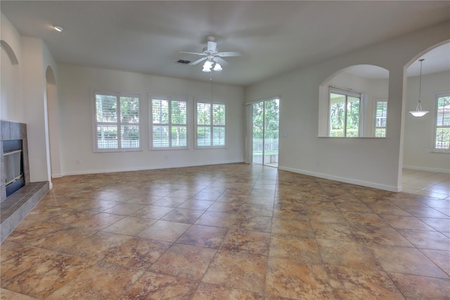 1679 Shadowmoss Cir, Lake Mary, FL 32746 - unfurnished living room with ceiling fan, a fireplace, and arched walkways