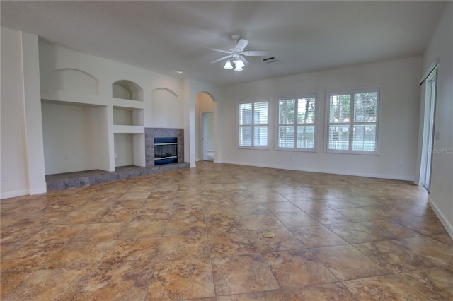 1679 Shadowmoss Cir, Lake Mary, FL 32746 - unfurnished living room featuring built in features, a fireplace, ceiling fan, and arched walkways