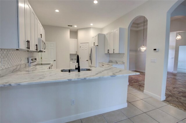 1679 Shadowmoss Cir, Lake Mary, FL 32746 - kitchen featuring white range with electric cooktop, fridge with ice dispenser, decorative backsplash, light stone counters, and a peninsula