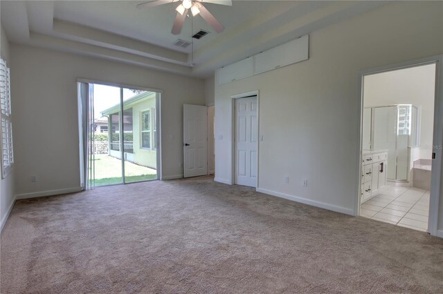 1679 Shadowmoss Cir, Lake Mary, FL 32746 - unfurnished bedroom with light colored carpet, a tray ceiling, access to outside, ensuite bathroom, and a ceiling fan
