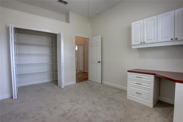 1679 Shadowmoss Cir, Lake Mary, FL 32746 - unfurnished bedroom with light colored carpet, built in desk, and a closet
