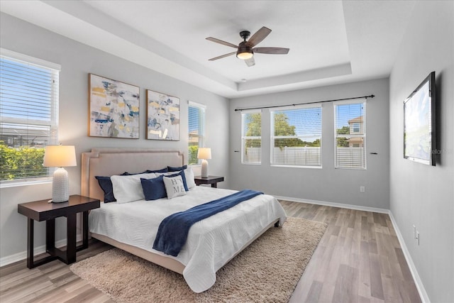 2781 Sand Oak Loop, Apopka, FL 32712 - bedroom with light wood-style flooring, a raised ceiling, and ceiling fan