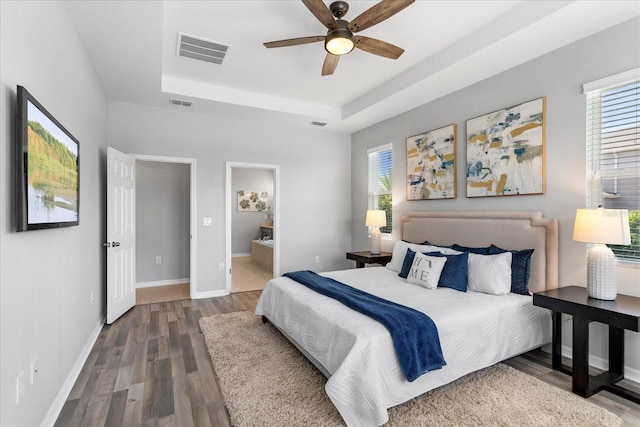 2781 Sand Oak Loop, Apopka, FL 32712 - bedroom with a raised ceiling, wood finished floors, multiple windows, and ensuite bathroom