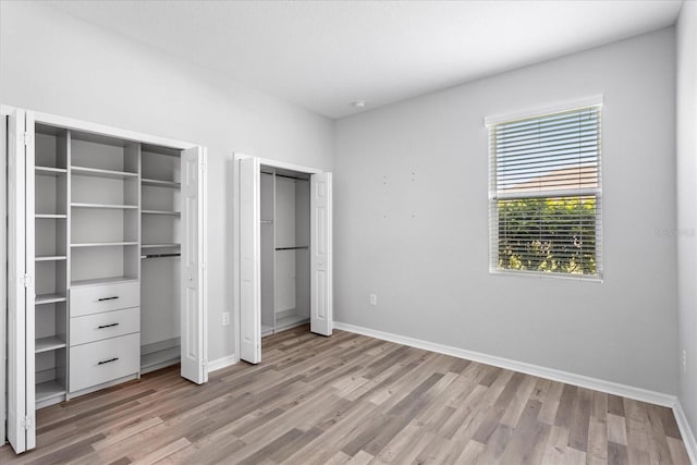 2781 Sand Oak Loop, Apopka, FL 32712 - unfurnished bedroom featuring two closets and light wood finished floors