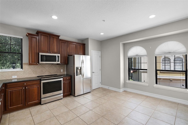 4244 Messina Dr, Lake Mary, FL 32746 - kitchen with appliances with stainless steel finishes, dark countertops, tasteful backsplash, recessed lighting, and light tile patterned floors