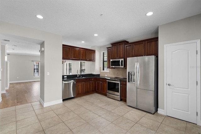 4244 Messina Dr, Lake Mary, FL 32746 - kitchen featuring stainless steel appliances, dark countertops, recessed lighting, backsplash, and light tile patterned flooring