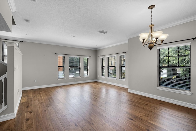 4244 Messina Dr, Lake Mary, FL 32746 - unfurnished living room featuring a chandelier, wood-type flooring, healthy amount of natural light, a textured ceiling, and crown molding