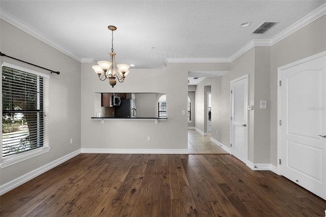 4244 Messina Dr, Lake Mary, FL 32746 - unfurnished dining area with a chandelier, ornamental molding, hardwood / wood-style flooring, and a textured ceiling