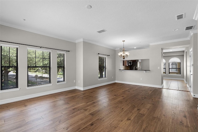 4244 Messina Dr, Lake Mary, FL 32746 - unfurnished living room featuring a chandelier, dark wood finished floors, a textured ceiling, and crown molding