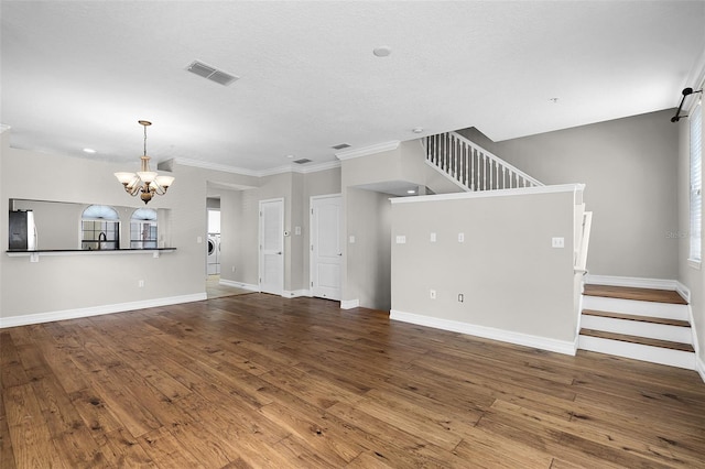 4244 Messina Dr, Lake Mary, FL 32746 - unfurnished living room with a chandelier, washer / dryer, hardwood / wood-style floors, stairway, and crown molding