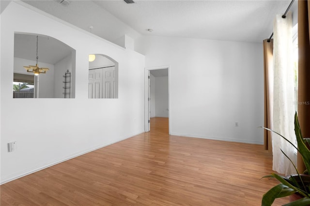 144 Fort Smith Blvd, Deltona, FL 32738 - unfurnished room with lofted ceiling, light wood-style floors, arched walkways, and a chandelier