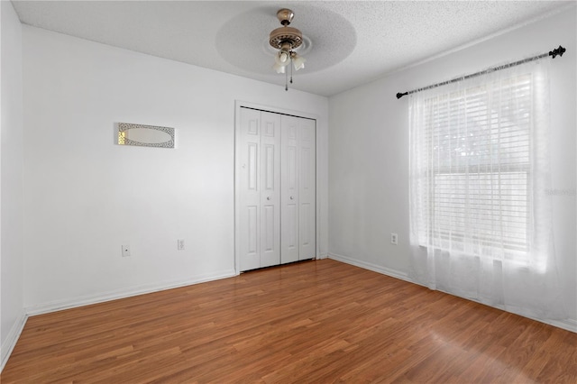 144 Fort Smith Blvd, Deltona, FL 32738 - unfurnished bedroom with wood finished floors, a ceiling fan, a closet, and a textured ceiling