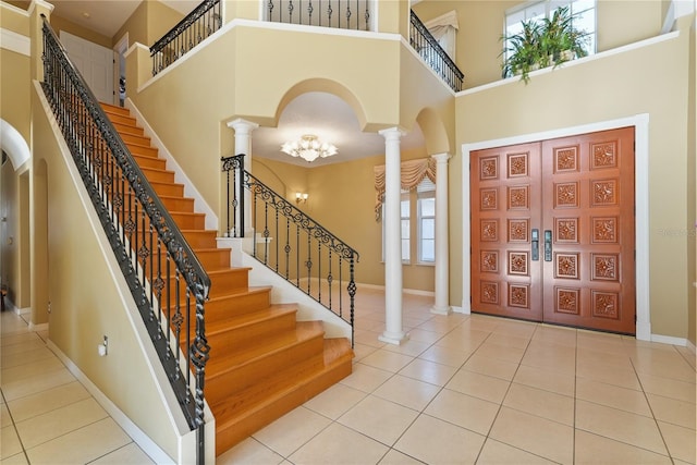 9128 Phillips Grove Ter, Orlando, FL 32836 - foyer entrance featuring a towering ceiling, decorative columns, tile patterned flooring, stairs, and arched walkways