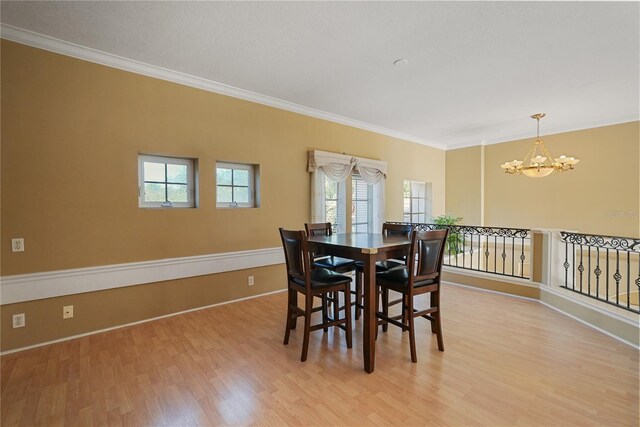 9128 Phillips Grove Ter, Orlando, FL 32836 - dining area featuring plenty of natural light, a chandelier, ornamental molding, and light wood-style flooring