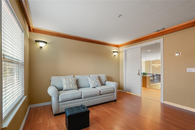 9128 Phillips Grove Ter, Orlando, FL 32836 - living area with wood finished floors, ornamental molding, a chandelier, and a textured ceiling