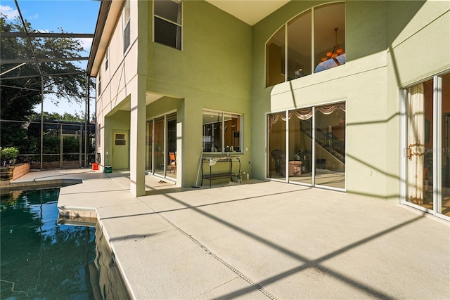 9128 Phillips Grove Ter, Orlando, FL 32836 - back of property with a patio, stucco siding, an outdoor pool, and glass enclosure