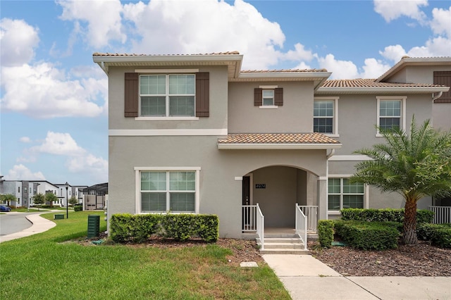 4974 Windermere Ave, Kissimmee, FL 34746 - view of property featuring a tiled roof, stucco siding, and a front lawn