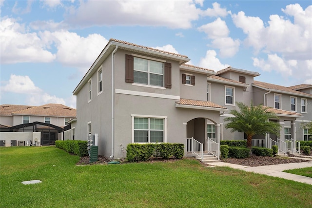 4974 Windermere Ave, Kissimmee, FL 34746 - view of front of home with a tiled roof, a front yard, and stucco siding