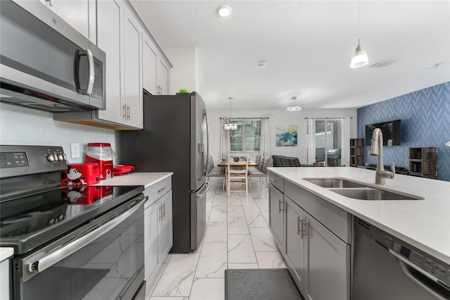 4974 Windermere Ave, Kissimmee, FL 34746 - kitchen with appliances with stainless steel finishes, wallpapered walls, light countertops, light marble finish floors, and open floor plan