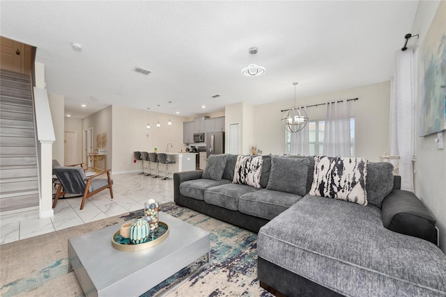 4974 Windermere Ave, Kissimmee, FL 34746 - living room with a chandelier, stairway, light marble finish floors, and recessed lighting