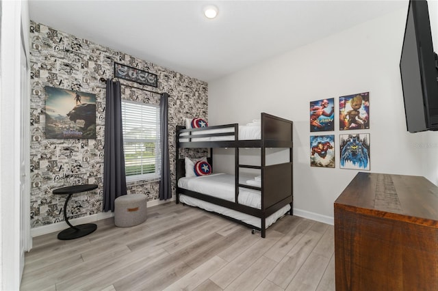 4974 Windermere Ave, Kissimmee, FL 34746 - bedroom with wallpapered walls, an accent wall, and light wood-style floors