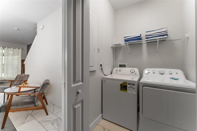 4974 Windermere Ave, Kissimmee, FL 34746 - laundry area with washer and clothes dryer and light marble finish flooring