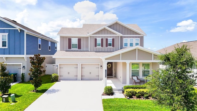 13993 Title Way, Winter Garden, FL 34787 - view of front of home featuring an attached garage, driveway, a porch, a front yard, and board and batten siding