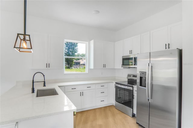 1006 Linkside Ct, Apopka, FL 32712 - kitchen with stainless steel appliances, a peninsula, white cabinets, and light stone counters