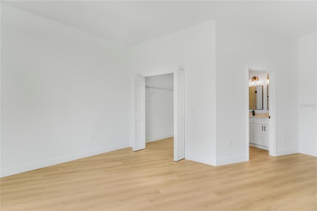 1006 Linkside Ct, Apopka, FL 32712 - unfurnished bedroom with light wood-style flooring, connected bathroom, a closet, and a walk in closet
