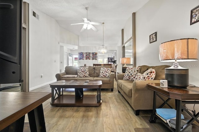 3280 Villa Way Cir, Saint Cloud, FL 34769 - living area featuring a ceiling fan, wood finished floors, high vaulted ceiling, and a chandelier