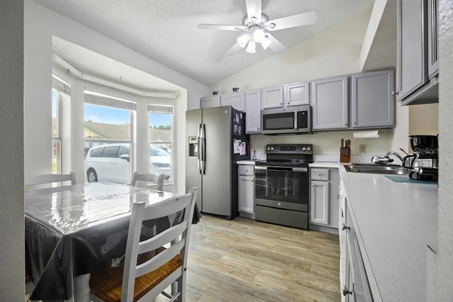 3280 Villa Way Cir, Saint Cloud, FL 34769 - kitchen with stainless steel appliances, vaulted ceiling, light wood finished floors, light countertops, and a ceiling fan
