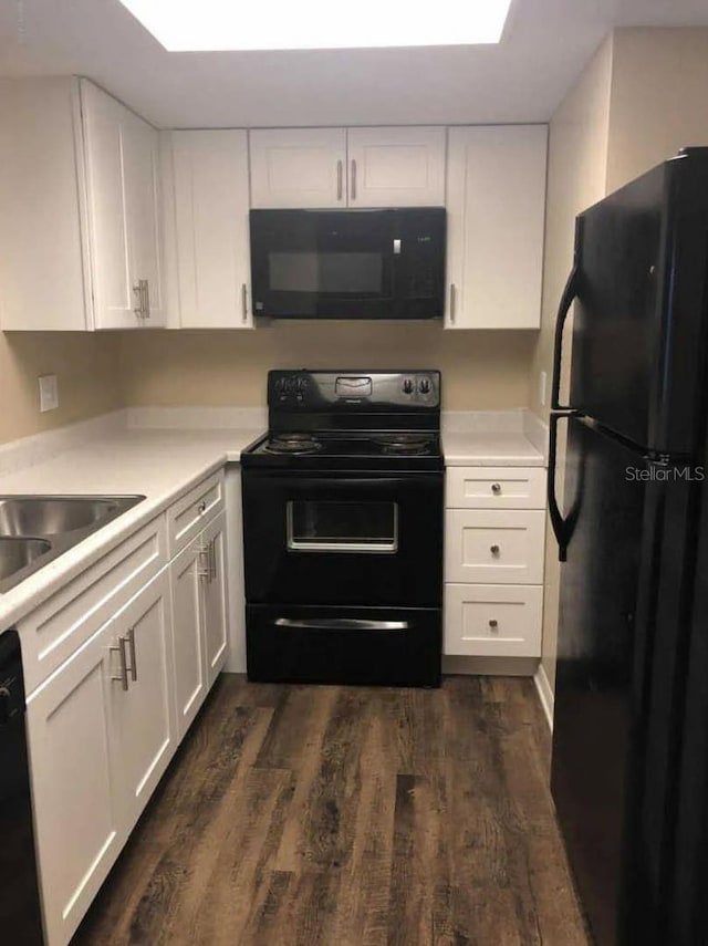 1042 Mollie Ln Unit 81042, Melbourne, FL 32935 - kitchen with black appliances, white cabinets, dark wood-type flooring, and light countertops